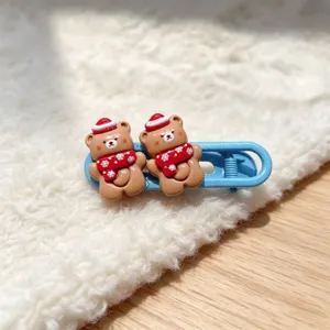 Close-up of cute Christmas bear hair clip detail, sweet design on blue pin, lovely accessory.