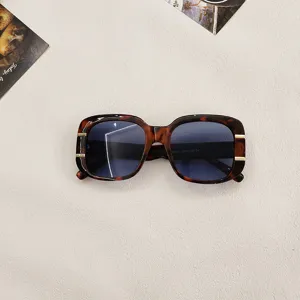 Close-up of trendy square tortoise sunglasses with chic gold metal accents for stylish looks.