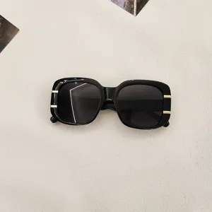 Stylish black square sunglasses with gold metal temple details for trendy street style and UV protection.