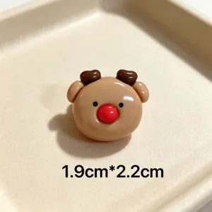 Close-up detail shot of cute cartoon reindeer Christmas brooch accessory with red nose.