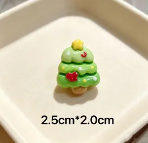 Close-up detail of a cute green resin Christmas tree brooch with star and bow decor.