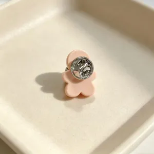 Close-up detail showing the back metal clasp of the cute pink gingerbread man brooch.