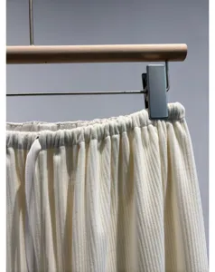 Close up view of lightweight pleated corduroy pants detail, soft texture and drawstring.