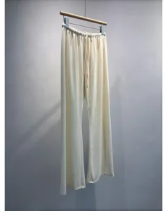 Detail view of comfortable pleated wide leg trousers featuring elastic drawstring waist texture.