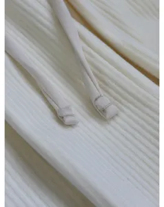 White soft ribbed corduroy trousers drawstring and fabric texture detail closeup