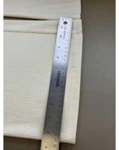 Detailed shot of ultra-thin corduroy fabric with ruler, showing the fine ribbed texture quality.