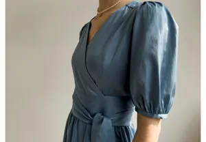 Robe bleue française à col V et manches bouffantes, design portefeuille élégant avec ceinture.