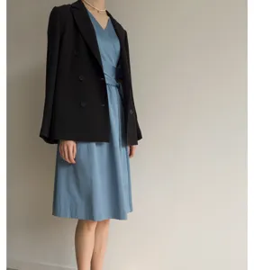 Vue de détail rapprochée d'une robe midi en coton française associée à un blazer noir élégant