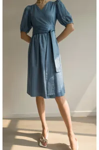 Gros plan détaillé sur la jolie robe française à manches bouffantes avec ceinture chic.