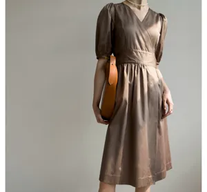 Vue détaillée d'une robe mi-longue marron de style français à col en V et manches bouffantes.