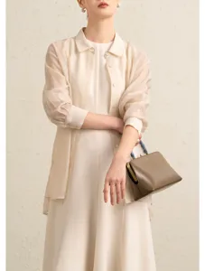 Elegant triacetate blend sleeveless umbrella swing dress with sheer shirt layering, texture.