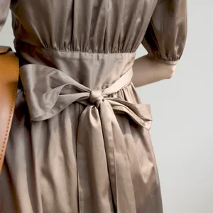 Élégante robe midi en satin marron avec nœud à la taille et manches bouffantes vue arrière.