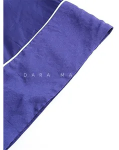 Détail de chemise de nuit en soie bleu foncé avec passepoil blanc et belle texture.
