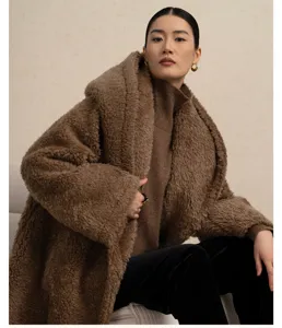 Detailed shot of a cozy brown teddy bear woolen coat with hood, worn by an Asian model.