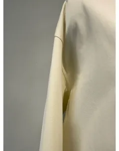 Close-up detail view of the cotton fabric shoulder and sleeve seam with fine texture.