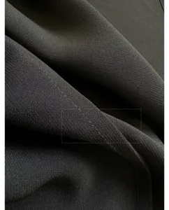 Detailed view of high-quality dark fabric texture with neat stitching craftsmanship.