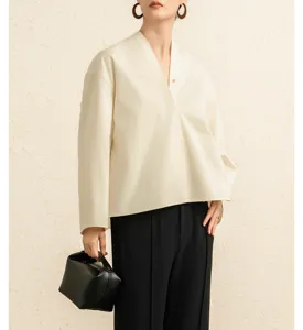 Detail shot of pure cotton poplin blouse with V-neck and wide sleeves in elegant style.