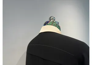 Close-up detail of black elegant acetate shirt featuring contrast collar and silk scarf.