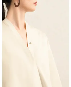 Detail shot of beige cotton poplin V-neck shirt featuring a modern hanfu collar and wide sleeves.