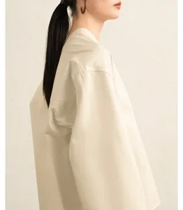 Elegant cotton poplin blouse with wide sleeves and a unique collar. Detail view of the stylish shirt.