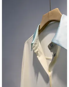 Elegant contrast collar shirt detail showing smooth acetate fabric and refined buttons.