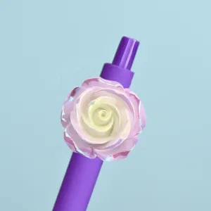 Close-up detail of the colorful gel pen featuring an iridescent camellia flower resin patch.