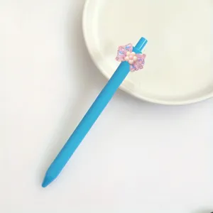 Close-up detail of the blue gel pen featuring a cute pink translucent bow resin patch.