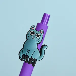 Gros plan détaillé de la jolie figurine de chat bleu avec des lunettes sur le stylo gel violet.
