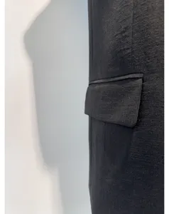 Close-up detail van vrouwen triacetaat blazer zak, ademende zomerjas textuur en kwaliteit.