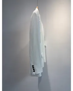 Gedetailleerd overzicht van de witte zomerblazer toont stofstructuur en mooie knopen.