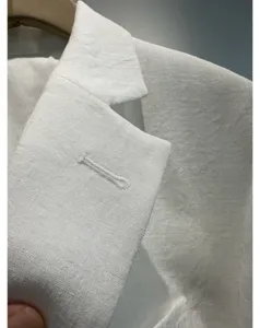 Wit blazer revers detail, fijne stoftextuur, zomer lichtgewicht pak close-up weergave.