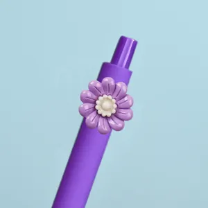 Detailansicht eines lila Gelstifts mit einer süßen Harzblumendekoration für das Büro.