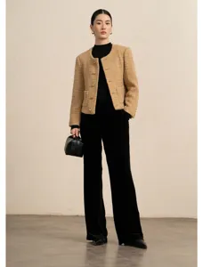 Gedetailleerd overzicht van elegante tweed jas gecombineerd met chique zwarte broek.