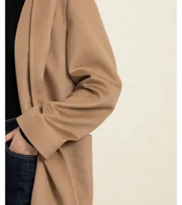Close-up detail of stylish camel wool coat sleeve and pocket, premium winter apparel texture.