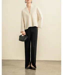 Minimalist V-neck blouse, wide sleeves and black split trousers detail shot, elegant style.