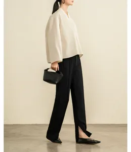 Detail view of the minimalist white V-neck cotton blouse, showcasing wide sleeves and elegant drape.