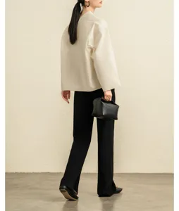 Detail shot of a women's cotton poplin short V-neck blouse in off-white, stylish wear.