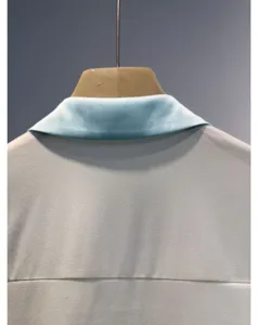 Elegant women's shirt detail featuring a contrasting blue collar and smooth fabric back view.