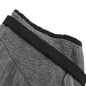Grey pleated skirt waistband detail, high waist design, elegant and stylish close-up view.