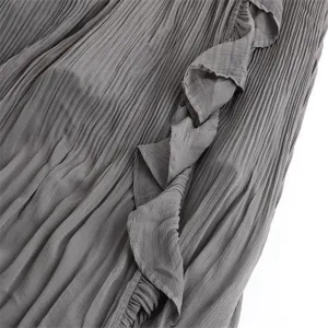 Grey pleated skirt detail close-up showing fine texture and elegant ruffle trimming design.