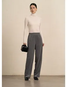 Detailed view of women knitted top and wide leg corduroy trousers outfit in studio setup.