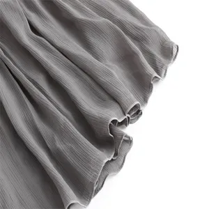 Detailed view of grey micro-pleated skirt fabric, showcasing exquisite lettuce hem craftsmanship.
