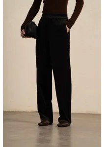Detail view of women's corduroy pants showing elastic waistband and smooth drape style.