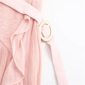 Pink high-waist pleated midi skirt detail with ruffle trim, matching belt and round buckle.