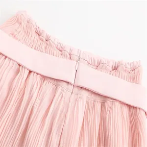 Pink pleated skirt waist detail close up, high waist design with lettuce edge and zipper.