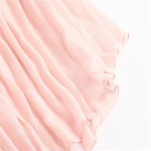 Exquisite pleated chiffon skirt fabric detail showing delicate pink color and lettuce edge design.