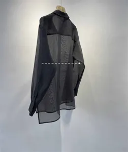 Detail view of the black sheer organza long sleeve shirt showing width measurement line.