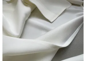 White acetate shirt fabric detail, smooth texture, exquisite collar stitching closeup shot.