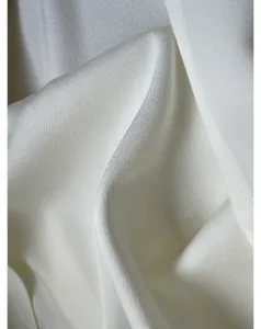 White silk fabric detail shot, smooth texture, elegant drape, high-end clothing material closeup.