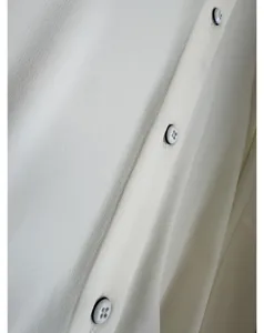 Detailed view of women white button down shirt smooth fabric texture close up apparel